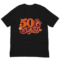 Black 50 & Sexy birthday T-shirt featuring orange and pink retro lettering with small flower and heart accents.